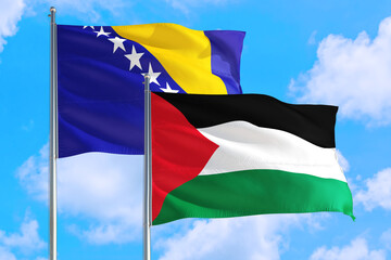 Palestine and Bosnia Herzegovina national flag waving in the windy deep blue sky. Diplomacy and international relations concept.