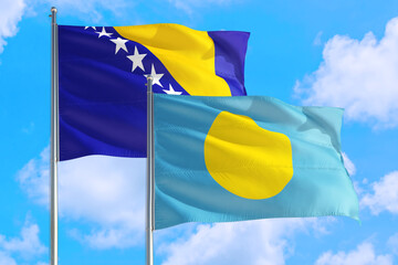 Palau and Bosnia Herzegovina national flag waving in the windy deep blue sky. Diplomacy and international relations concept.