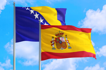 Spain and Bosnia Herzegovina national flag waving in the windy deep blue sky. Diplomacy and international relations concept.