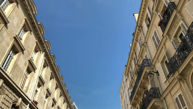 Bottom footage of historical, traditional, typical buildings in Paris showing French / Parisian architectural style. It is a sunny summer day. Camera moves forward.