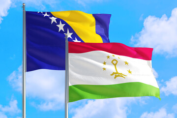 Tajikistan and Bosnia Herzegovina national flag waving in the windy deep blue sky. Diplomacy and international relations concept.