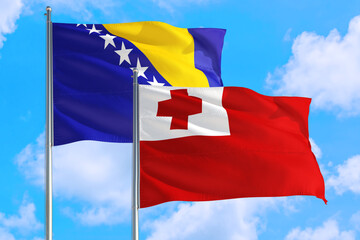 Tonga and Bosnia Herzegovina national flag waving in the windy deep blue sky. Diplomacy and international relations concept.