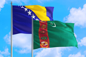 Turkmenistan and Bosnia Herzegovina national flag waving in the windy deep blue sky. Diplomacy and...