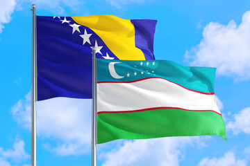 Uzbekistan and Bosnia Herzegovina national flag waving in the windy deep blue sky. Diplomacy and...