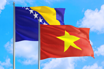 Vietnam and Bosnia Herzegovina national flag waving in the windy deep blue sky. Diplomacy and...