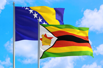 Zimbabwe and Bosnia Herzegovina national flag waving in the windy deep blue sky. Diplomacy and international relations concept.