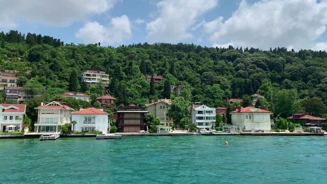 Footage of luxury houses in upscale neighborhood called "Kandilli" by Bosphorus in Istanbul. It is a beautiful summer scene on cloudy summer day. Camera moves forward.