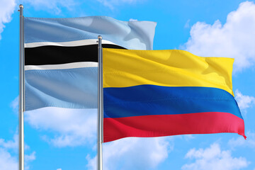 Colombia and Botswana national flag waving in the windy deep blue sky. Diplomacy and international relations concept.