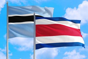 Costa Rica and Botswana national flag waving in the windy deep blue sky. Diplomacy and international relations concept.