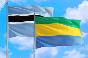 Gabon and Botswana national flag waving in the windy deep blue sky. Diplomacy and international...