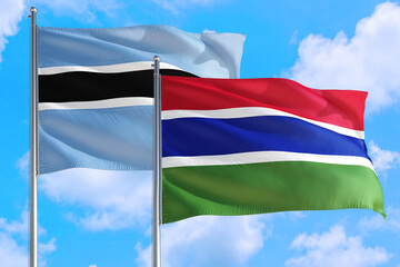 Gambia and Botswana national flag waving in the windy deep blue sky. Diplomacy and international relations concept.