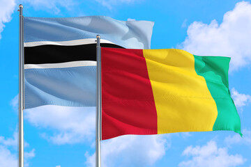 Guinea Bissau and Botswana national flag waving in the windy deep blue sky. Diplomacy and international relations concept.