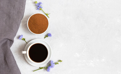Composition of chicory drink, powder, blue flowers and gray napkin on a white background. Natural coffee substitute Copy space, top view, flat lay.