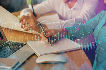 Double exposure of forex chart drawing over people taking notes background. Concept of financial analysis