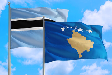 Kosovo and Botswana national flag waving in the windy deep blue sky. Diplomacy and international relations concept.