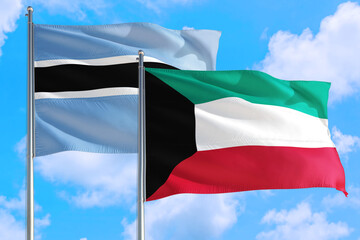 Kuwait and Botswana national flag waving in the windy deep blue sky. Diplomacy and international relations concept.