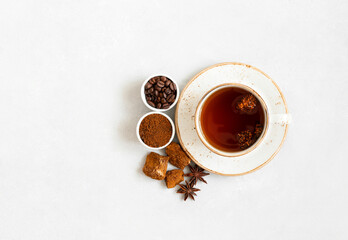 Obraz na płótnie Canvas Cup with mushroom chaga drink and coffee on a white background. Trendy superfood. Space for text. Top view, flat lay.