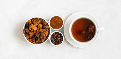 Chaga mushroom drink with coffee and chopped chaga pieces on a white background. New superfood trend. Top view, flat lay.