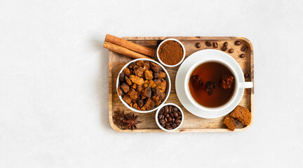 Chaga mushroom drink with coffee in a wooden tray on a white background. Copy space, top view, flat lay.