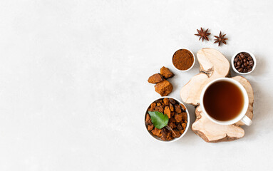 Obraz na płótnie Canvas Mushroom chaga drink with coffee on a white background. Coffee beans, chopped pieces of chaga, anise and a cup with a healthy drink. Copy space, top view, flat lay.