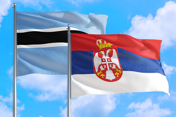 Serbia and Botswana national flag waving in the windy deep blue sky. Diplomacy and international relations concept.