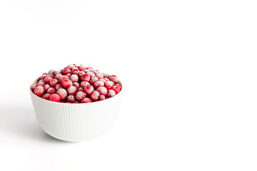 Frozen cranberries isolated on a white background. Red berries with frost in a bowl. Copy space.