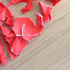 pieces of torn red paper on wood background