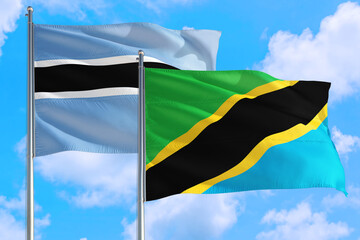 Tanzania and Botswana national flag waving in the windy deep blue sky. Diplomacy and international relations concept.