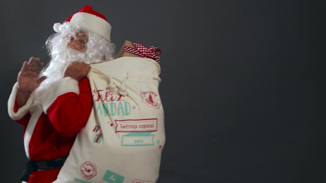 Papa noel con bolsa de regalos caminando entregando en navidad