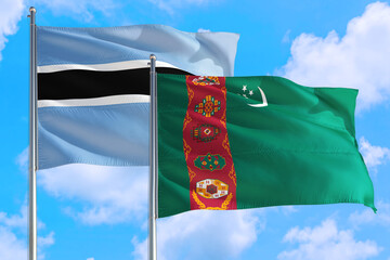Turkmenistan and Botswana national flag waving in the windy deep blue sky. Diplomacy and...