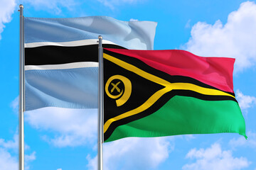 Vanuatu and Botswana national flag waving in the windy deep blue sky. Diplomacy and international relations concept.