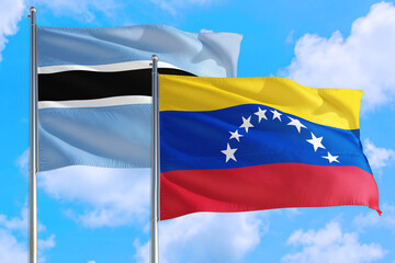 Venezuela and Botswana national flag waving in the windy deep blue sky. Diplomacy and international relations concept.