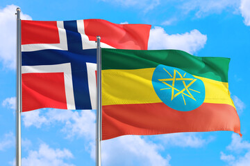Ethiopia and Bouvet Islands national flag waving in the windy deep blue sky. Diplomacy and international relations concept.