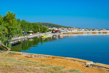 Fototapeta premium Argostoli's tranquil Koutavos Lagoon reflects a vibrant scene of colorful boats and a picturesque waterfront.The iconic De Bosset bridge stretches across the calm waters, connecting the town