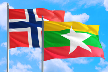 Myanmar and Bouvet Islands national flag waving in the windy deep blue sky. Diplomacy and international relations concept.