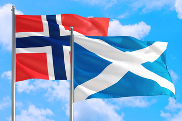 Scotland and Bouvet Islands national flag waving in the windy deep blue sky. Diplomacy and international relations concept.