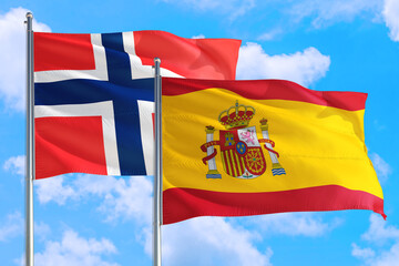 Spain and Bouvet Islands national flag waving in the windy deep blue sky. Diplomacy and international relations concept.
