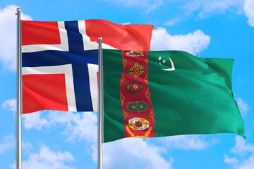 Turkmenistan and Bouvet Islands national flag waving in the windy deep blue sky. Diplomacy and...