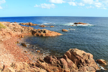 Fototapeta na wymiar Red rocks on the coastline