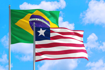 Libya and Brazil national flag waving in the windy deep blue sky. Diplomacy and international...