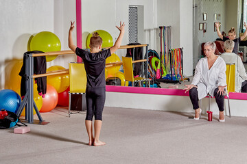 A teacher teaches a student at a ballet school. Sports lifestyle and body flexibility. A woman...