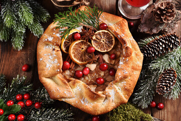 rustic style apple tart with cranberries and spices on Christmas table