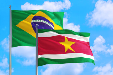 Swaziland and Brazil national flag waving in the windy deep blue sky. Diplomacy and international...
