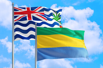 Gabon and British Indian Ocean Territory national flag waving in blue sky. Diplomacy and international relations concept.