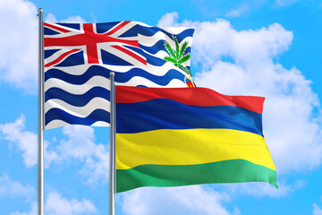 Mauritius and British Indian Ocean Territory national flag waving in blue sky. Diplomacy and international relations concept.