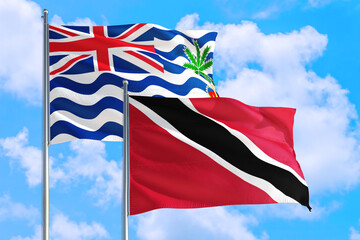Trinidad And Tobago and British Indian Ocean Territory national flag waving in blue sky. Diplomacy and international relations concept.