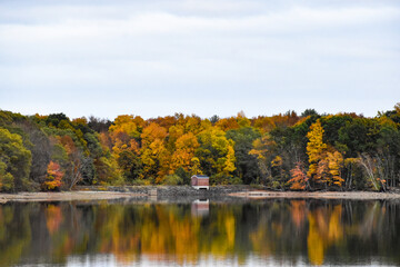 Small pump house on a reservoir in the fall