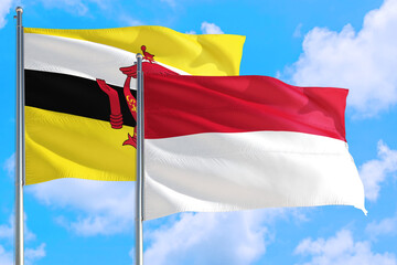 Indonesia and Brunei national flag waving in the windy deep blue sky. Diplomacy and international relations concept.
