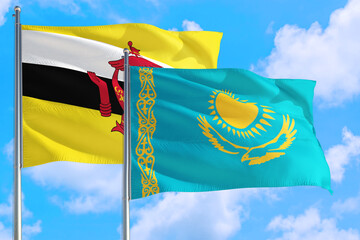 Kazakhstan and Brunei national flag waving in the windy deep blue sky. Diplomacy and international relations concept.