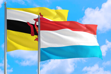 Luxembourg and Brunei national flag waving in the windy deep blue sky. Diplomacy and international relations concept.